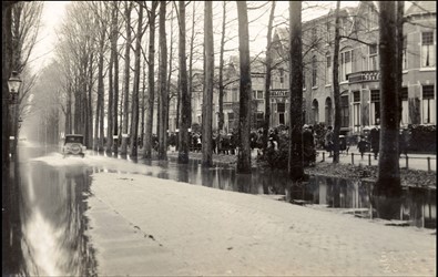 <p>Zutphen heeft altijd veel last gehad van wateroverlast, zeker tot aan de dichting van de Baakse overlaat vanaf 1949. Bij een overstroming in 1926 liepen de lager gelegen gronden rond de stad onder water. Op de foto is de ondergelopen Deventerweg te zien. Voorbijgangers staan 'hoog en droog' op de ventweg (Regionaal Archief Zutphen). </p>
